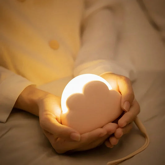 Person holding a cloud-shaped night light with text about soft light eye protection.