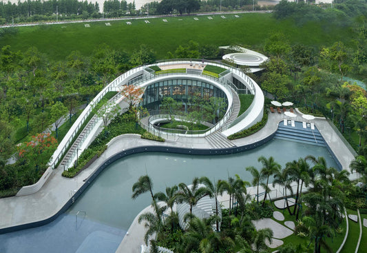 Aerial view of a unique spiral architectural structure in a lush tropical park.