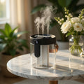 Humidifier emitting steam on a marble table with plants and flowers in the background