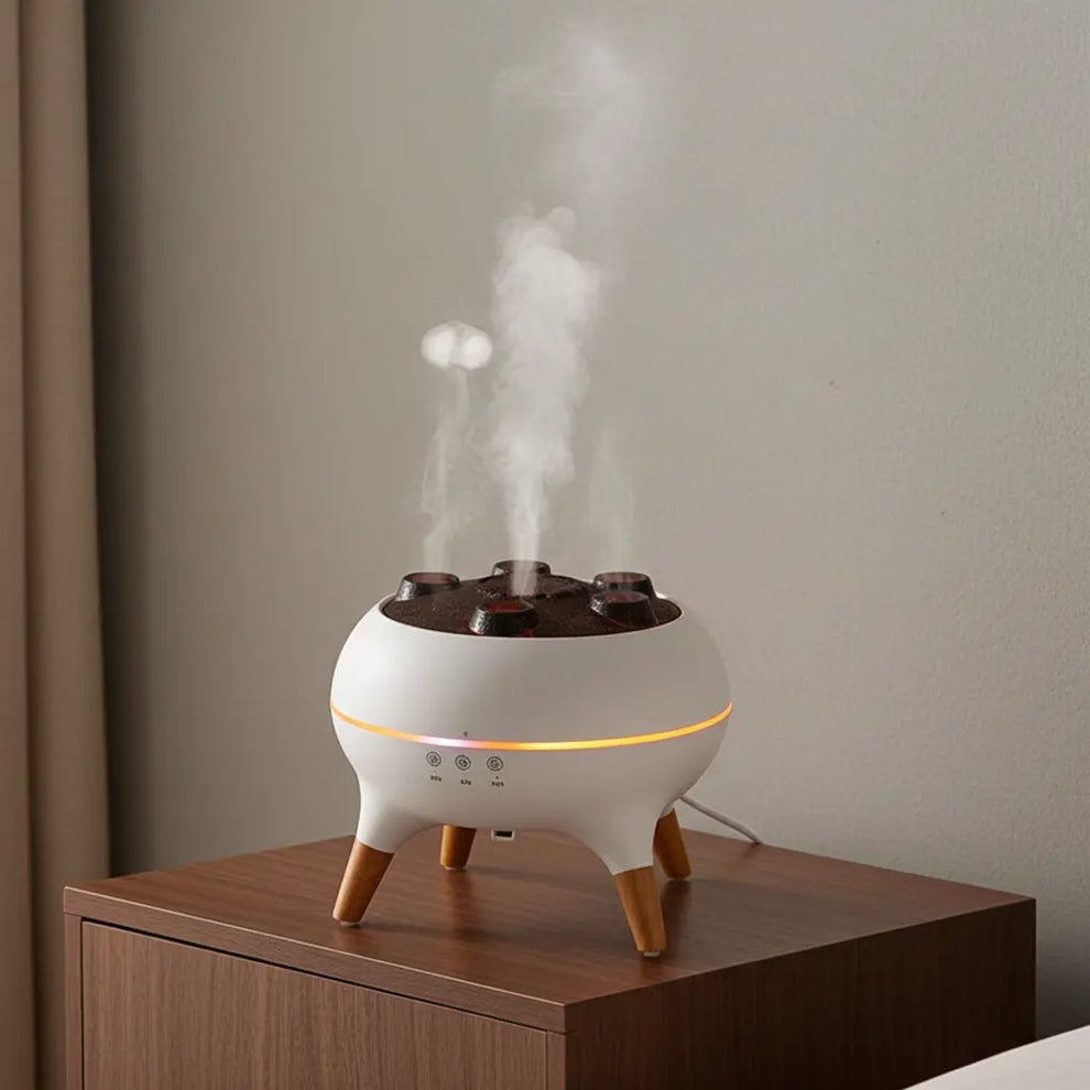 White diffuser with wooden legs emitting steam on a wooden surface against a plain wall.