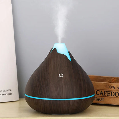 Ultrasonic aromatherapy essential oil diffuser with soft LED light on bedroom table creating mist